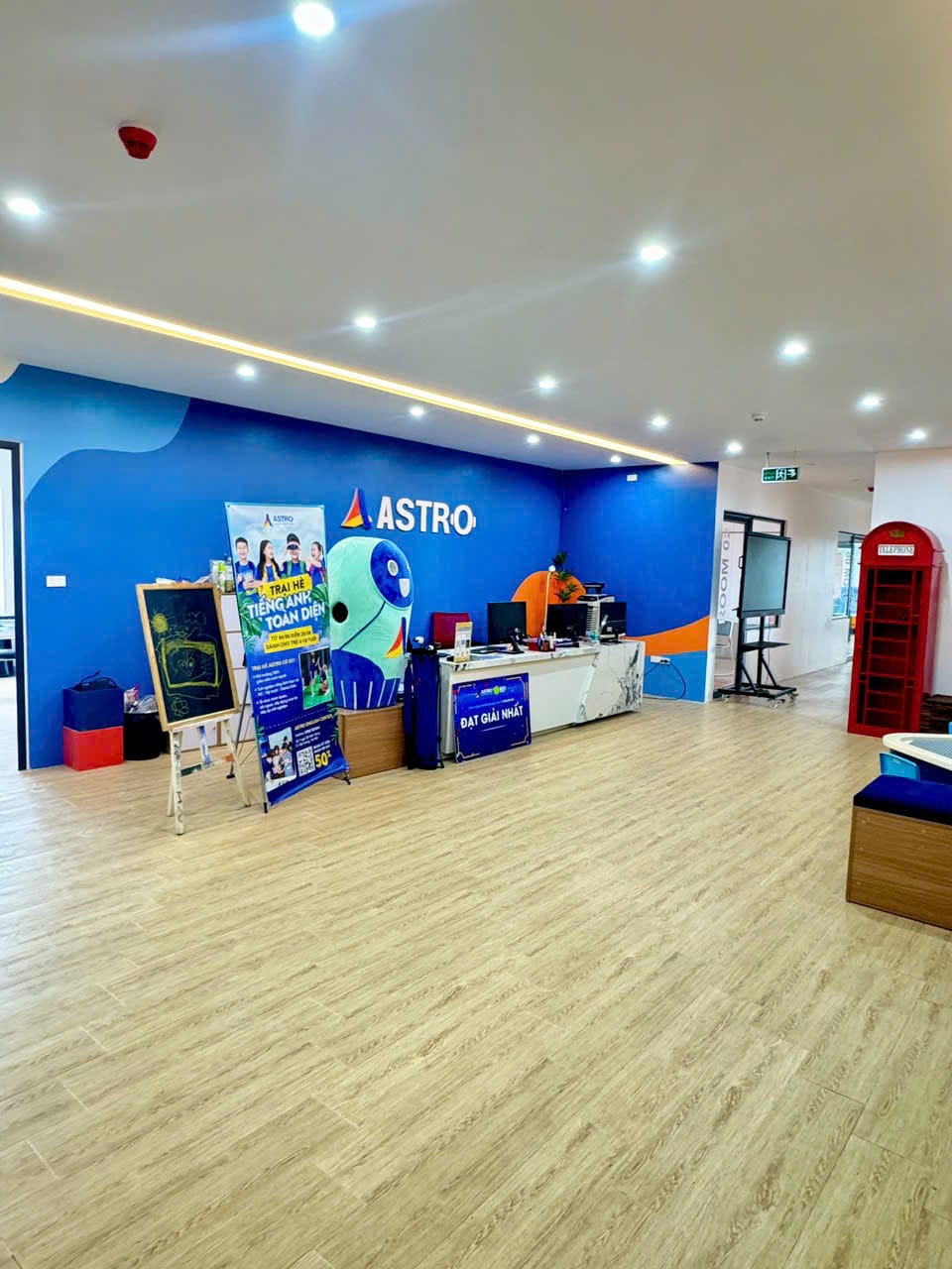 Quầy lễ tân Astro với tường xanh có logo ASTRO
